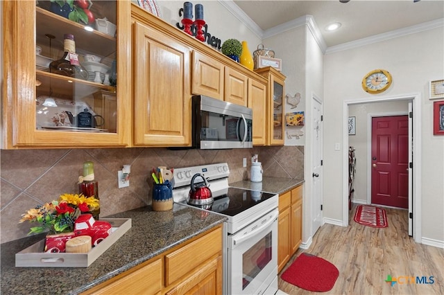 kitchen with white electric stove, light hardwood / wood-style floors, dark stone counters, decorative backsplash, and ornamental molding