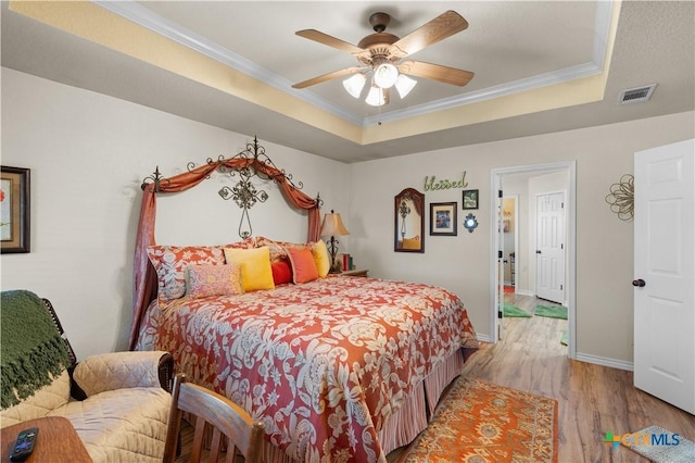 bedroom featuring a tray ceiling, ceiling fan, and ornamental molding