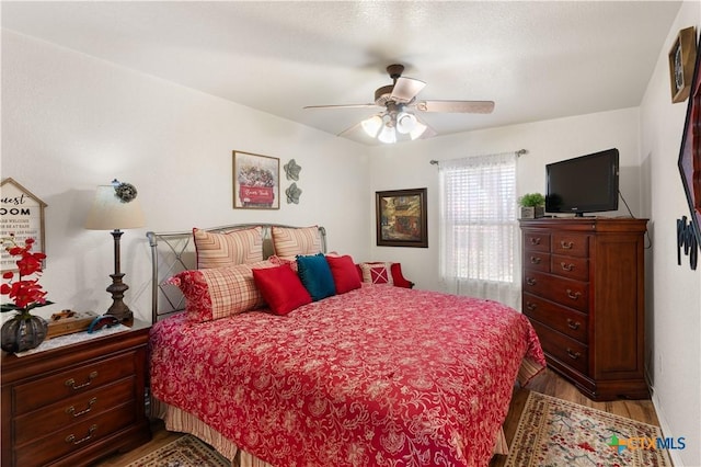 bedroom with ceiling fan and hardwood / wood-style floors