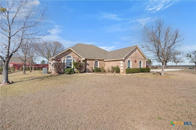 ranch-style house with central air condition unit and a front yard