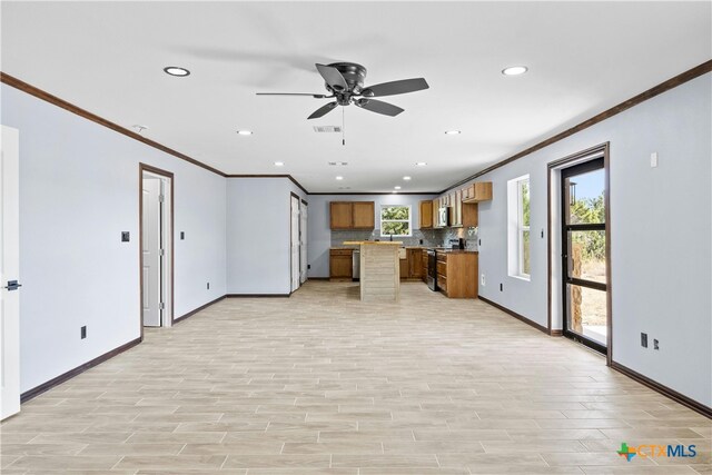 kitchen with light wood-type flooring, backsplash, appliances with stainless steel finishes, and ornamental molding