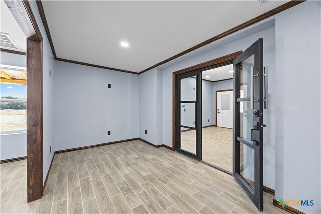 unfurnished room featuring light wood-type flooring and crown molding