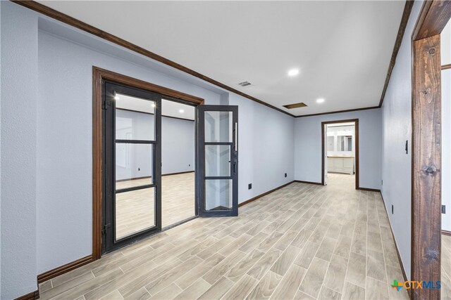 spare room with light wood-type flooring and ornamental molding