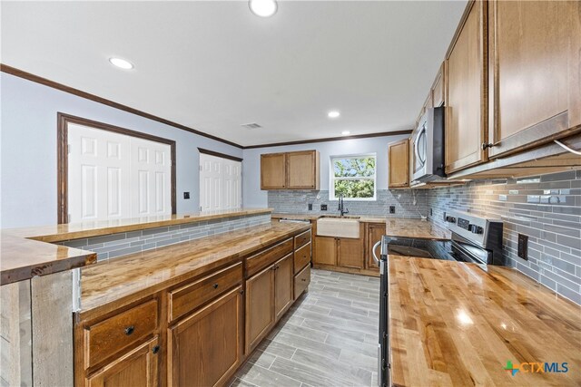 kitchen featuring wooden counters, sink, and crown molding