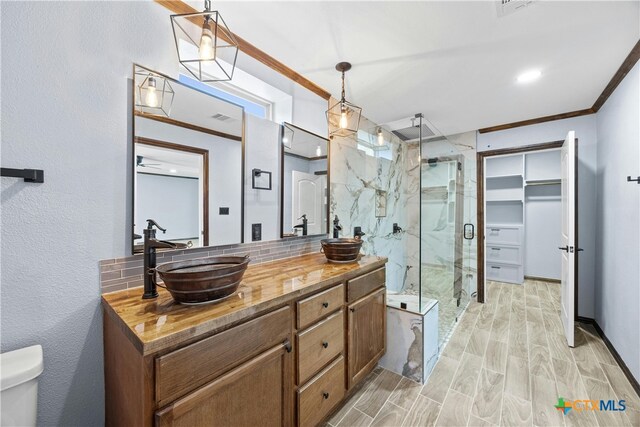 bathroom featuring walk in shower, wood-type flooring, crown molding, and vanity