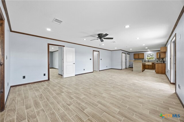 unfurnished living room featuring light wood-type flooring, ceiling fan, and crown molding