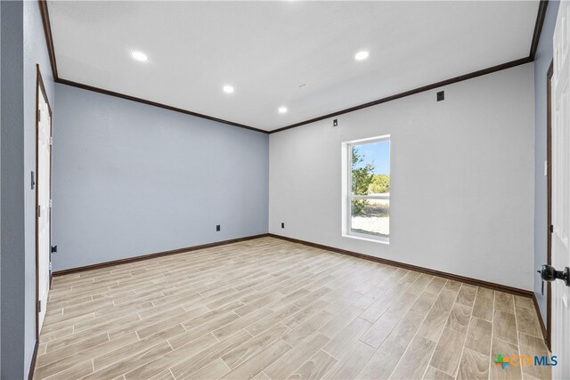 empty room featuring ornamental molding and light hardwood / wood-style floors