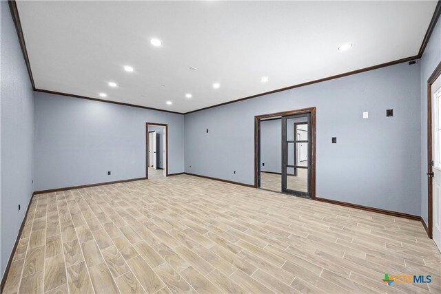 empty room featuring light hardwood / wood-style floors and crown molding