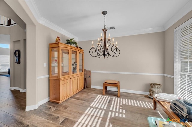 dining area with crown molding, baseboards, visible vents, and light wood finished floors