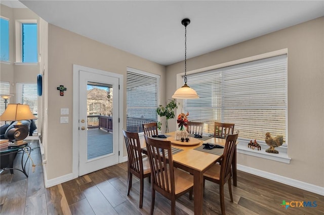 dining room featuring plenty of natural light, baseboards, and dark wood-style flooring