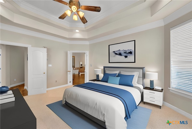 bedroom with a tray ceiling, baseboards, a ceiling fan, and crown molding