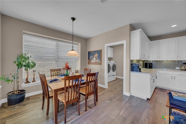 dining area with baseboards, plenty of natural light, wood finished floors, and washing machine and clothes dryer