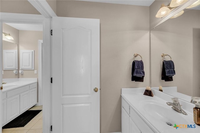 bathroom featuring tile patterned floors, two vanities, and a sink