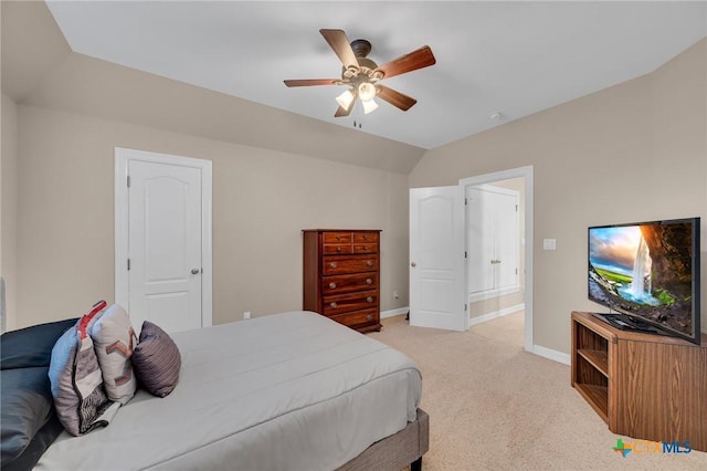 bedroom featuring a ceiling fan, vaulted ceiling, light colored carpet, and baseboards