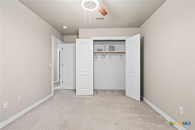 unfurnished bedroom with a closet, visible vents, carpet flooring, ceiling fan, and baseboards