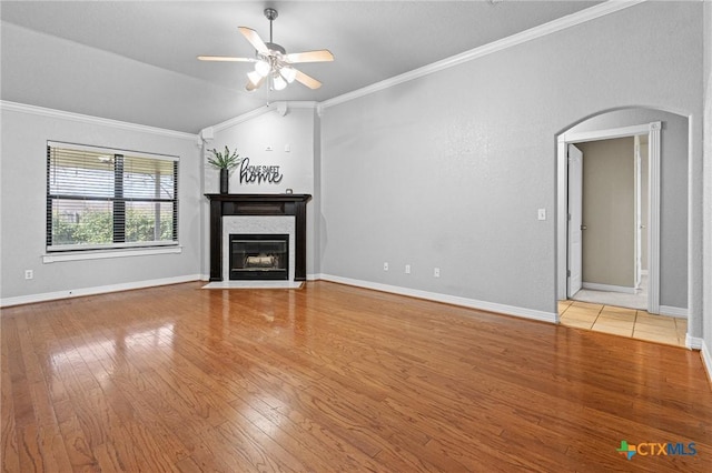 unfurnished living room with ornamental molding, light wood-type flooring, ceiling fan, and a fireplace with flush hearth