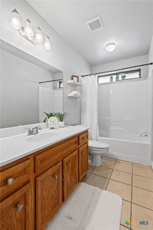 full bath with visible vents, shower / bathtub combination with curtain, toilet, vanity, and tile patterned flooring