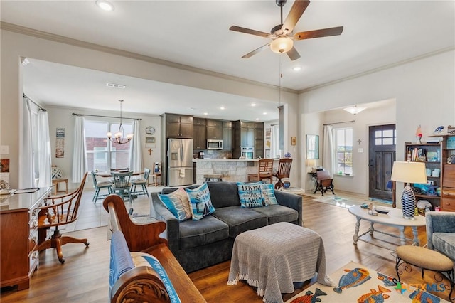 living room featuring a healthy amount of sunlight, light hardwood / wood-style floors, and crown molding