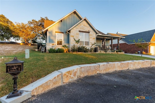 view of front of house featuring covered porch and a front lawn