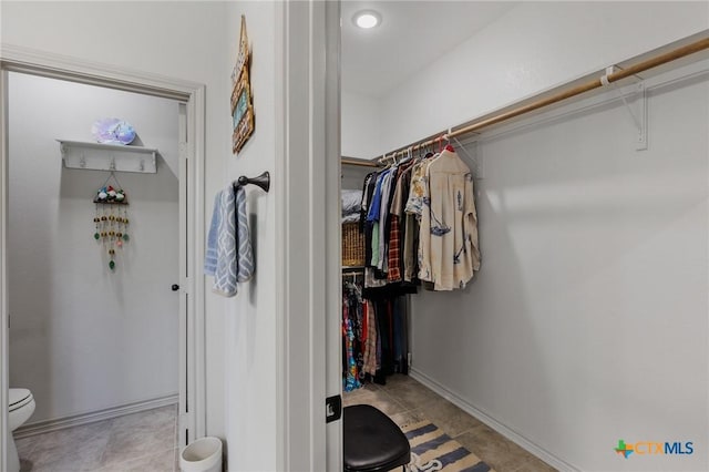 walk in closet with light tile patterned flooring