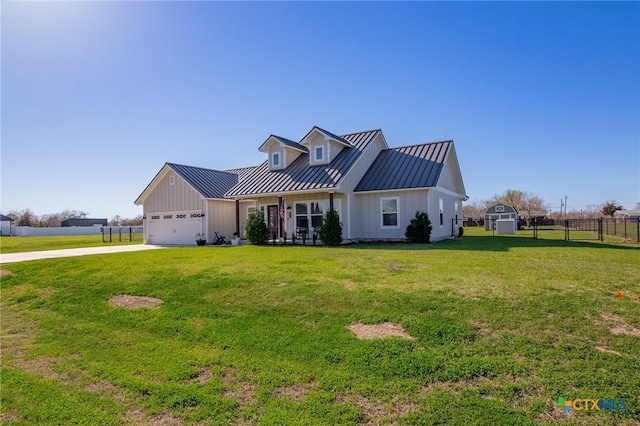 view of front of house featuring fence, a front yard, metal roof, a garage, and a standing seam roof