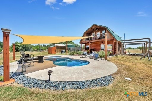 view of swimming pool featuring a storage unit and a patio