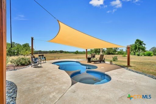 view of swimming pool with a patio area and an in ground hot tub