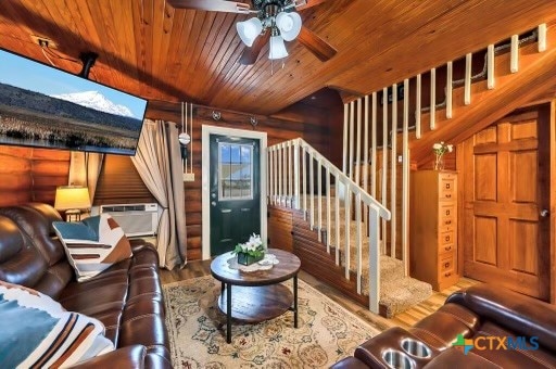 living room with wood walls, wood ceiling, hardwood / wood-style flooring, and ceiling fan