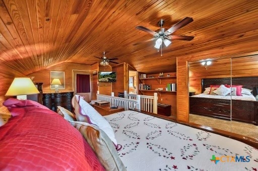 bedroom featuring wood walls, wood ceiling, and vaulted ceiling