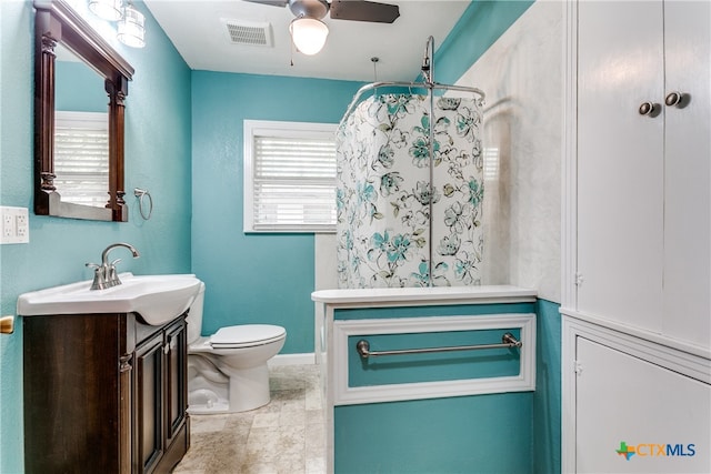 bathroom featuring toilet, vanity, and ceiling fan