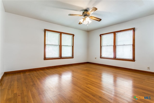 unfurnished room featuring hardwood / wood-style floors, plenty of natural light, and ceiling fan