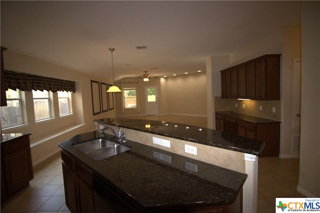 2005 Granite Springs Rd, Leander, TX 78641 - kitchen with a sink, a kitchen island with sink, light tile patterned flooring, and a ceiling fan
