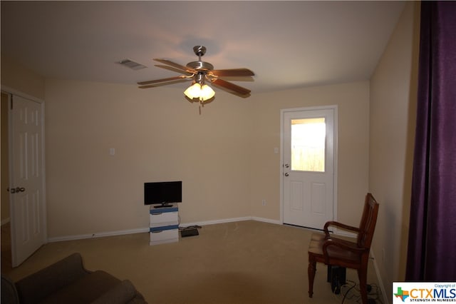 carpeted living room with ceiling fan