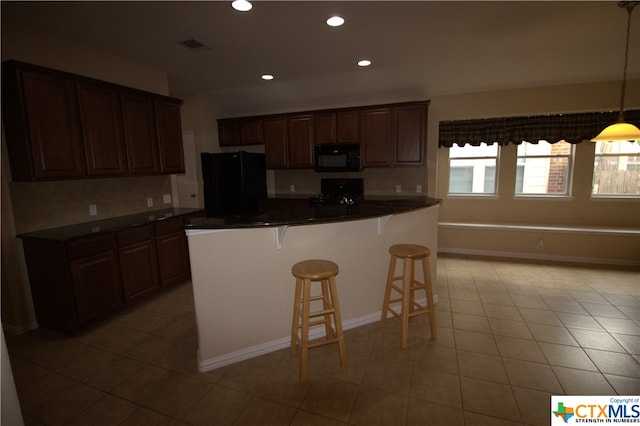 2005 Granite Springs Rd, Leander, TX 78641 - kitchen with black appliances, dark countertops, a breakfast bar area, recessed lighting, and pendant lighting