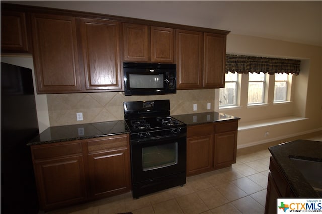 kitchen featuring black appliances, backsplash, dark stone countertops, and light tile patterned flooring