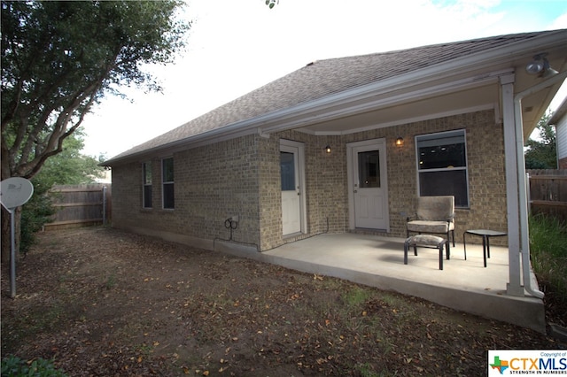 2005 Granite Springs Rd, Leander, TX 78641 - rear view of property with brick siding, fence, roof with shingles, and a patio area
