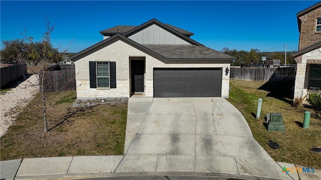2023 Chilton Hall, San Antonio, TX 78253 - view of front of home featuring a garage, board and batten siding, concrete driveway, and fence