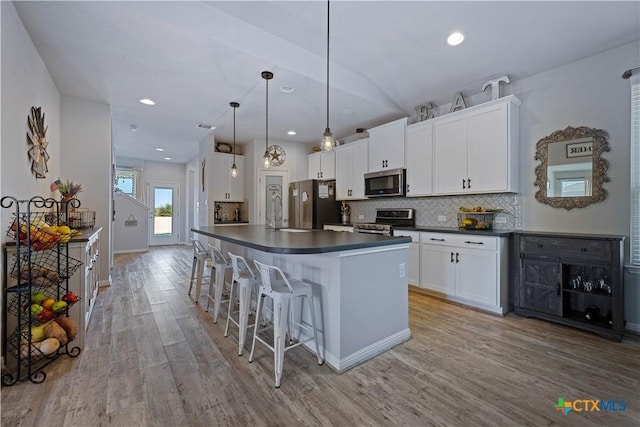 2023 Chilton Hall, San Antonio, TX 78253 - kitchen with dark countertops, white cabinetry, light wood-style flooring, backsplash, and appliances with stainless steel finishes