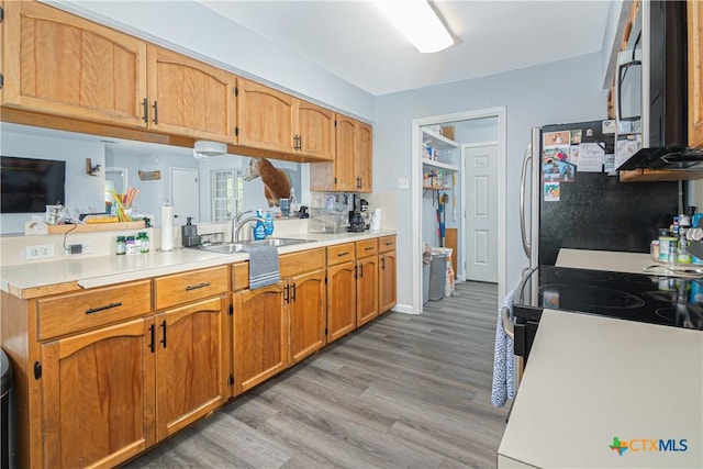 160 Tanglewood Dr, Seguin, TX 78155 - kitchen featuring light countertops, light wood-style floors, a sink, and brown cabinets