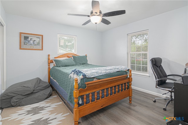 bedroom featuring multiple windows, wood-type flooring, and ceiling fan