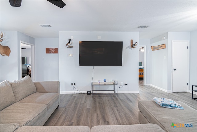 living room with wood-type flooring and ceiling fan