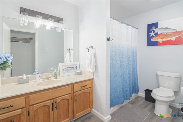 bathroom featuring toilet, vanity, and hardwood / wood-style flooring