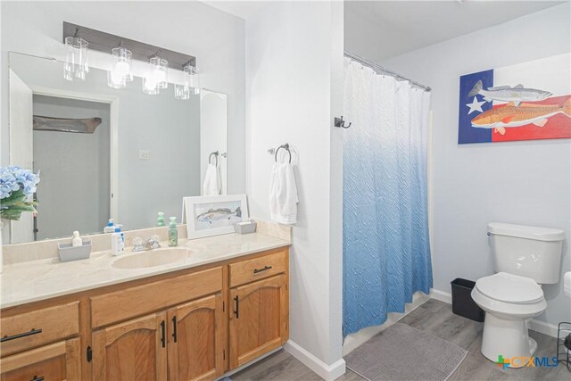 160 Tanglewood Dr, Seguin, TX 78155 - bathroom featuring vanity, wood finished floors, toilet, and baseboards