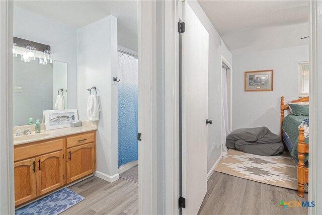 160 Tanglewood Dr, Seguin, TX 78155 - full bathroom featuring wood finished floors, vanity, connected bathroom, and baseboards