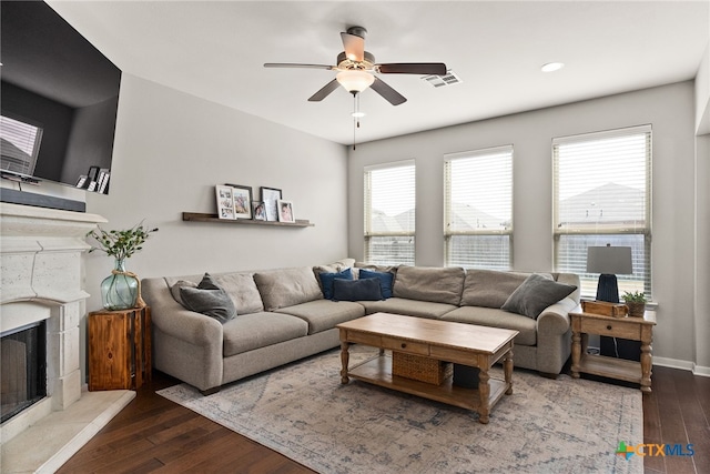 living room featuring hardwood / wood-style flooring, a wealth of natural light, and a tile fireplace