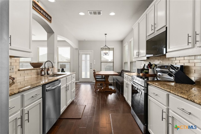 kitchen featuring dark hardwood / wood-style flooring, white cabinetry, appliances with stainless steel finishes, and a healthy amount of sunlight