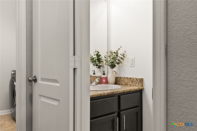 bathroom with washer / dryer, tile patterned flooring, and vanity