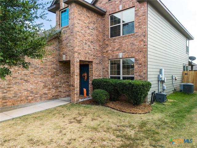 view of front facade featuring central AC unit and a front yard