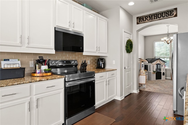 kitchen with appliances with stainless steel finishes, dark stone countertops, backsplash, white cabinets, and dark wood-type flooring