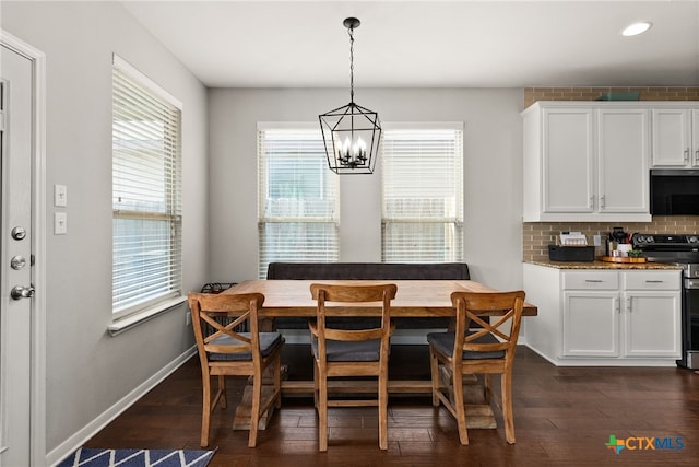 dining area featuring dark wood-type flooring and a chandelier